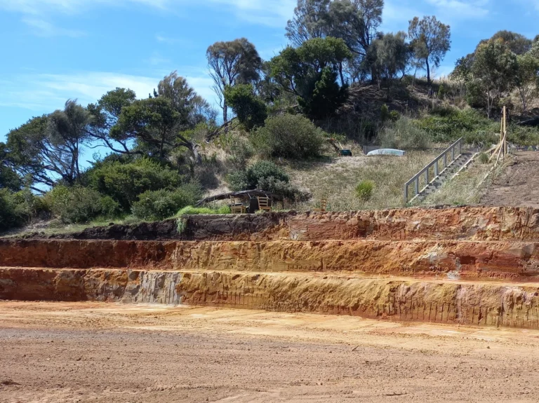 Tiered site cut excavation on a large hill surrounded by trees
